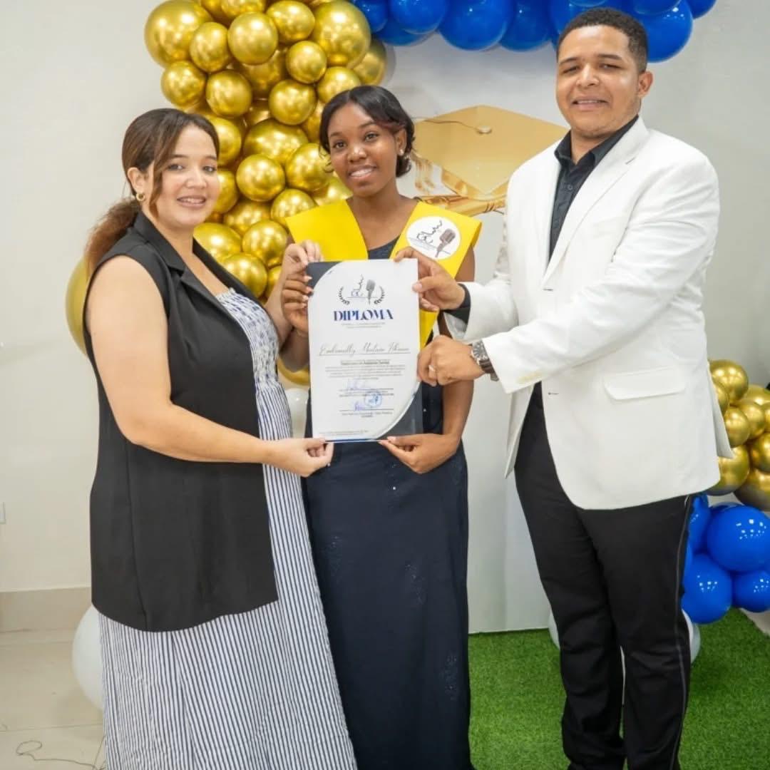 Egresada recibiendo su diploma junto al equipo del instituto